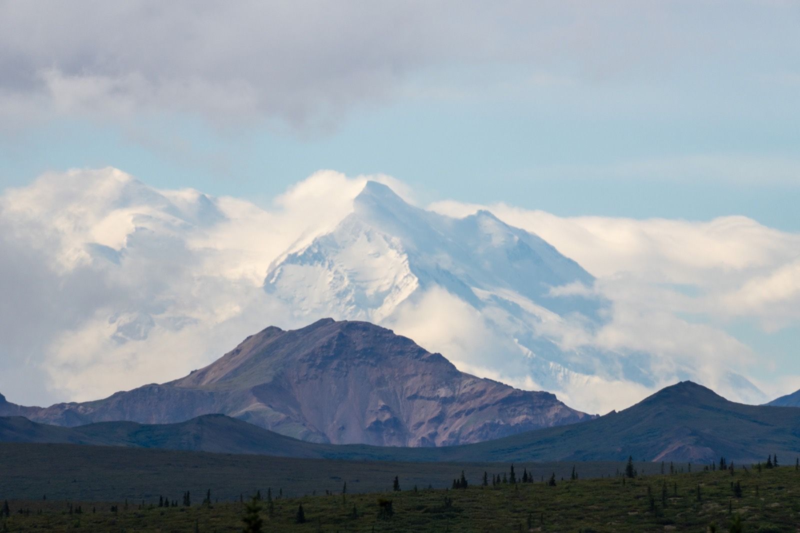 Clouds surrounding Denali above open tundra