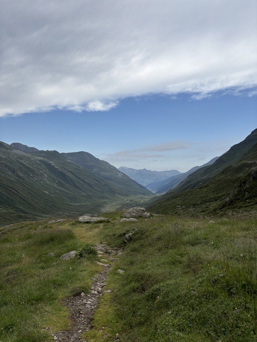 Narrow trail descending through the green Dischma valley towards Dürrboden