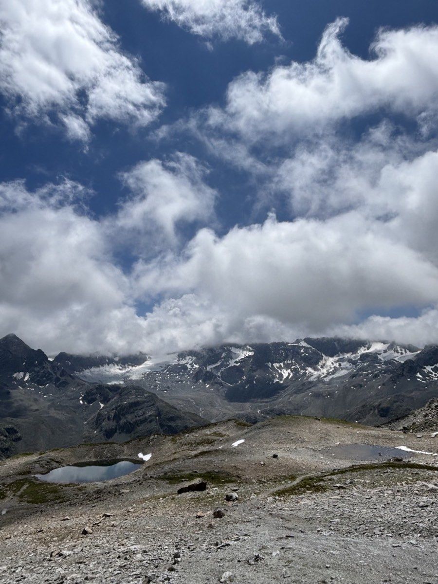 Bare high-alpine basin, snow patches and cloud near Schwarzhornfurgga