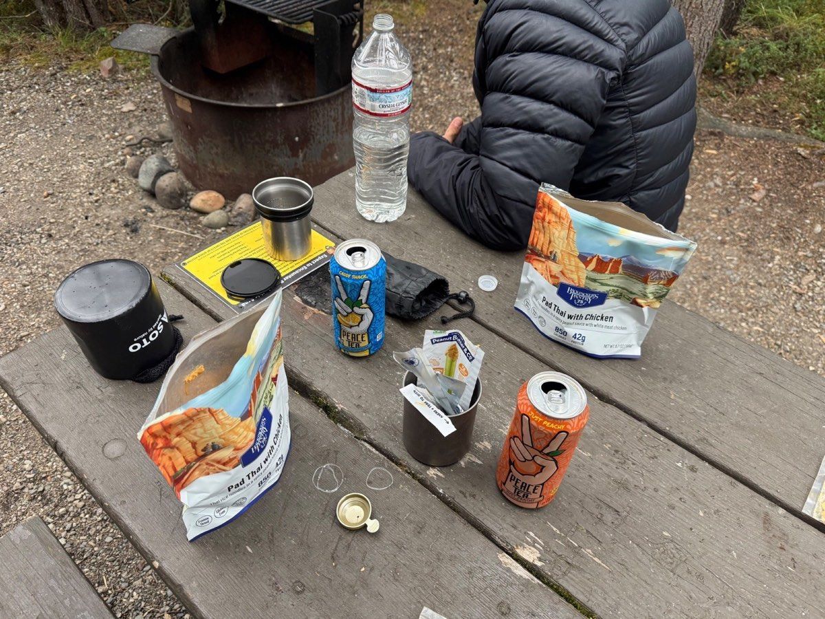 Camp meal, stove and warm jacket on a Riley Creek picnic table