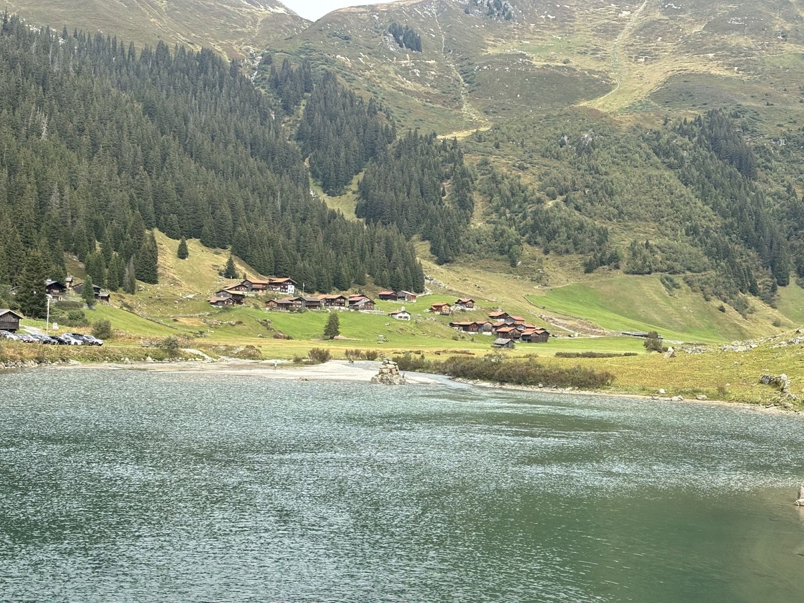 Schlappin village and lake below broad green mountain slopes