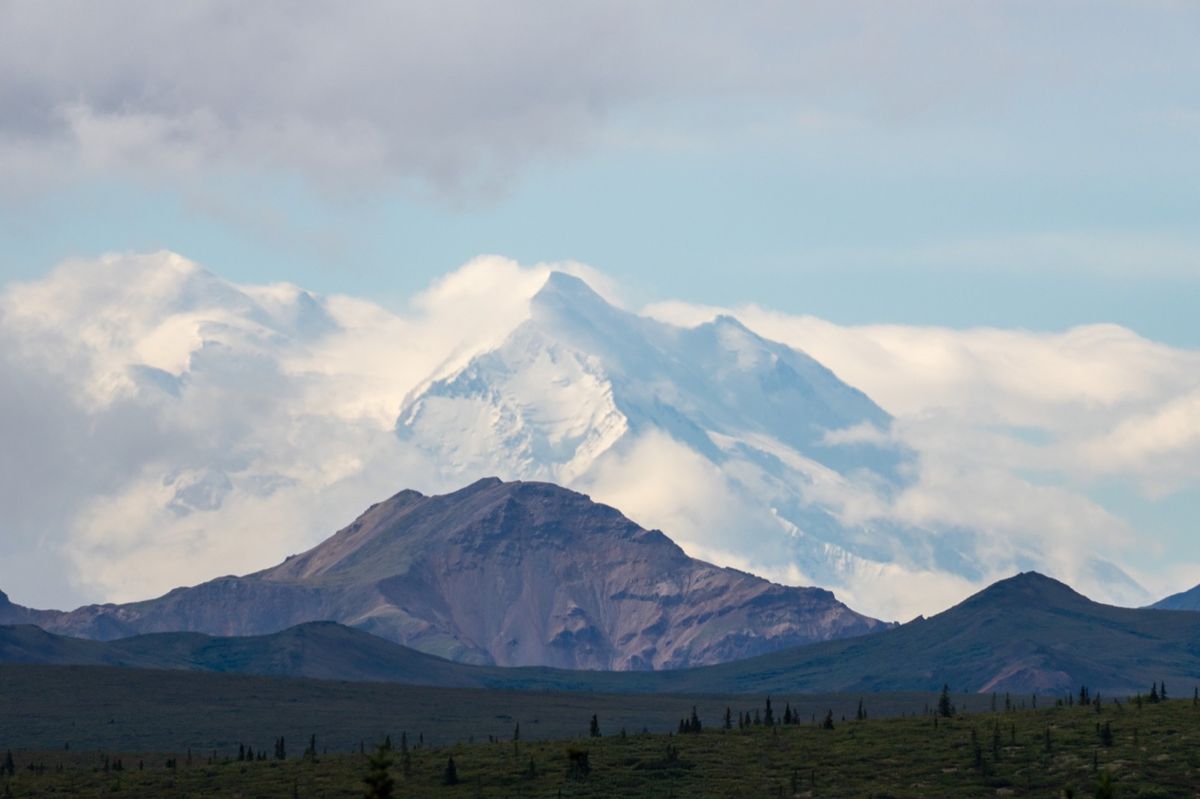 Clouds surrounding Denali above open tundra