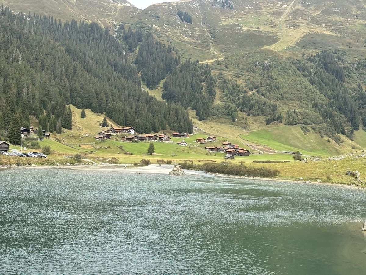 Schlappin village and lake below broad green mountain slopes