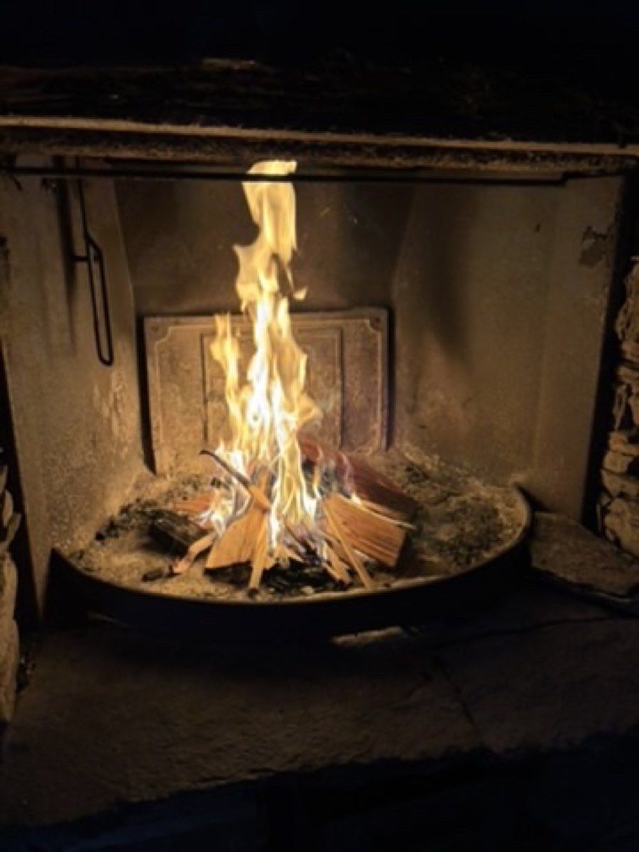 A newly lit fire inside a simple stone hut