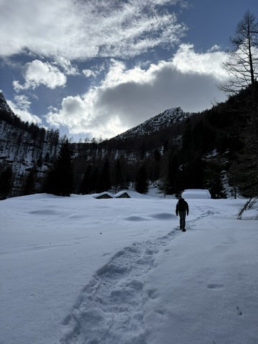 A hiker following the previous day's track back through deep snow