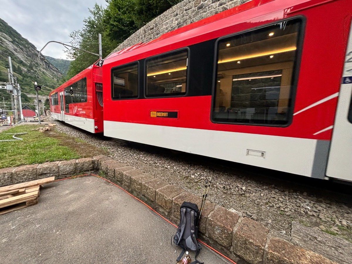 A red mountain railway beside a waiting hiking pack
